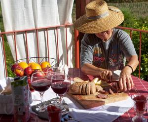 a man cutting meat on a table with glasses of wine at Quinta da Peça Douro Wine Region Retreat, Private Pool Villa in Vila Real +59 photos