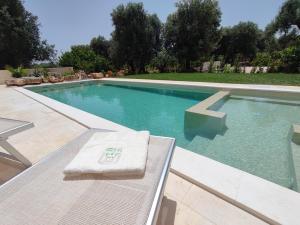 a swimming pool with a towel on a bench next to it at La casa nel villaggio in Montalbano
