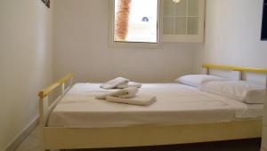 two beds in a room with towels on them at Punta d'Arancia Holiday House in Marina di Ragusa