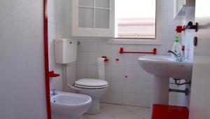 a small bathroom with a toilet and a sink at Punta d'Arancia Holiday House in Marina di Ragusa +35 photos