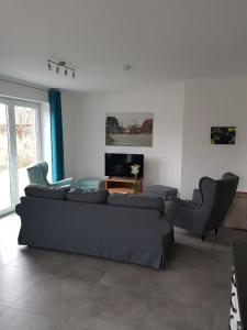 a living room with a black couch and chairs at Wunderschönes Appartement in Fedderwardersiel mit Terrasse in Butjadingen