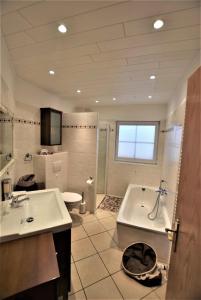 a bathroom with a tub and a sink and a toilet at Bernstein-Chalet unten in Hohwacht
