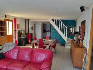 a living room with a red couch and a table at Maison a côté du pal in Saligny-sur-Roudon