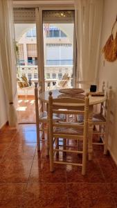 une table et des chaises dans une pièce avec une fenêtre dans l'établissement Torrevieja Seaside Escape, à Torrevieja