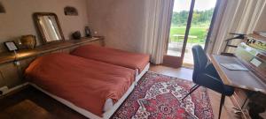 a bedroom with a bed and a desk and a mirror at La Ferme de Menoun in Thil