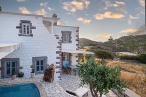 a villa with a swimming pool next to a house at Theologos Houses in Grikos