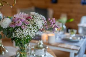 a vase filled with flowers on a table at Hygge Lodge Annecy in Doussard