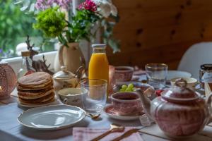 a table with plates of food and a jug of orange juice at Hygge Lodge Annecy in Doussard