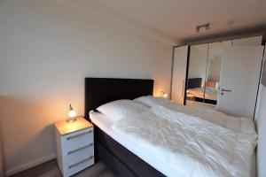 ホーヴァハトにあるMeeresblick "Seesternchen" Haus 3 WE 41のベッドと鏡付きのドレッサーのある寝室