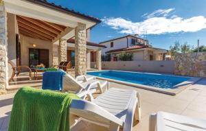 einen Hinterhof mit Pool und Stühlen und ein Haus in der Unterkunft Charakteristisches Ferienhaus im Dorf Kavran, gelegen in einer landschaftlich schönen Umgebung in Kavran