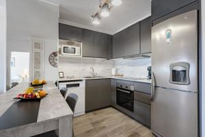 una cocina con electrodomésticos de acero inoxidable y una mesa con fruta. en Balcon Smart Home Hi-End Services Media Streaming, en Adeje