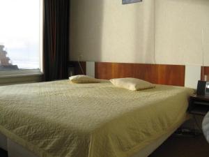 ein Schlafzimmer mit einem Bett mit zwei Kissen darauf in der Unterkunft het Zeehuisje in Egmond aan Zee