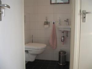 ein Badezimmer mit Toilette und Waschbecken in der Unterkunft het Zeehuisje in Egmond aan Zee + 16 Fotos