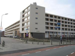 ein großes weißes Gebäude am Straßenrand in der Unterkunft het Zeehuisje in Egmond aan Zee