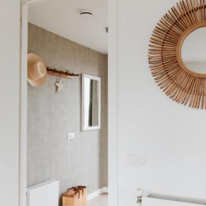 Un pasillo con un espejo en la pared. en Villa Duinhuis Zee, en Egmond aan den Hoef