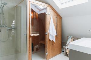 Un baño con ducha y puerta trasera de cristal. en Villa Duinhuis Zee, en Egmond aan den Hoef 19 fotos más