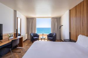 a hotel room with a bed and a view of the ocean at Radisson Blu Acqua Hotel & Spa Concon in Concón +53 photos