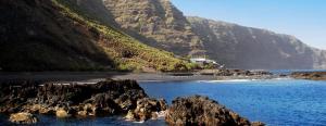 a view of a beach with rocks and a mountain at APTO 1103 MESA DEL MAR in Puerto de la Madera