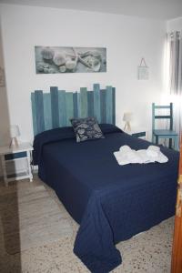 a bedroom with a blue bed with towels on it at APTO 1103 MESA DEL MAR in Puerto de la Madera