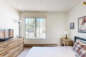 een slaapkamer met een bed, een tv en een raam bij Ski Bowl Condos Unit 518 in Truckee