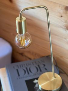 a lamp sitting on a table next to a book at Hygge Lodge Annecy in Doussard
