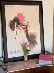 a picture of a girl sitting on a table with a vase with flowers at Hygge Lodge Annecy in Doussard