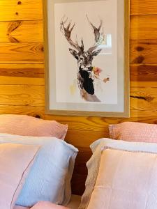 a bedroom with two beds and a picture of a deer at Hygge Lodge Annecy in Doussard