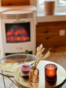 a table with a vase with flowers and a stove at Hygge Lodge Annecy in Doussard