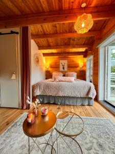 a bedroom with a large bed and a table at Hygge Lodge Annecy in Doussard
