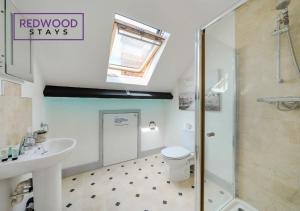 a bathroom with a shower and a toilet and a sink at Comfortable and Homely 1-Bedroom 1-Bathroom Serviced Apartment, Free Parking, Free WiFi By Redwood Stays in Farnborough