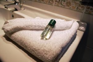 a bottle sitting on top of a white towel on a sink at Paradise Bay Resort in Mellieħa