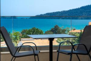 クリッシ・アモウディアにあるFINIKAS LUXURY SUITES Thassos Golden Beachのテーブルと椅子、水辺の景色を望むバルコニー