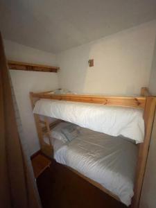 una camera con letto a castello e lenzuola bianche di le jaillet a Megève