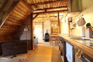 Il comprend une cuisine avec des murs et un plafond en bois. dans l'établissement Ferienhaushälfte Gösselberg im Ferienhaus Anno Dazumal, wie zu Großmutters Zeiten, à Klingenthal