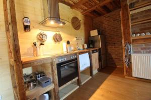 - une cuisine dotée de murs en bois et d'un four avec plaques de cuisson dans l'établissement Ferienhaushälfte Gösselberg im Ferienhaus Anno Dazumal, wie zu Großmutters Zeiten, à Klingenthal