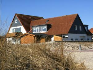 ホーヴァハトにあるLuv und Lee - Strandperleの海岸沿いにある茶色の屋根の家