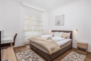 a bedroom with a bed and a desk in it at Amelia & Julia apartments in Rijeka