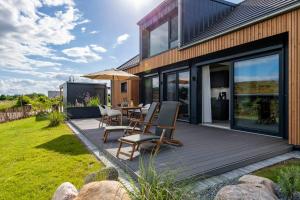 a deck with a table and chairs on a house at Strandgänger Hohwacht in Hohwacht