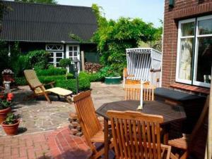 un patio avec quatre chaises et une table avec dans l'établissement Das Marschenhaus, à Butjadingen