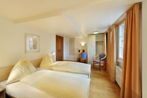Habitación de hotel con 2 camas y mesa en Gasthaus Paxmontana, en Sachseln