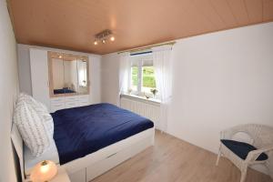 a bedroom with a blue bed and a window at Haus Steinkamp in Blekendorf