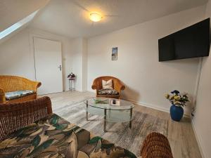 a living room with two chairs and a table and a tv at Haus Steinkamp in Blekendorf