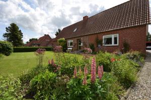 a garden in front of a house with flowers at Haus Steinkamp in Blekendorf