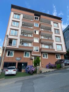 a tall building with a car parked in front of it at TULİPA SUİTEs TRABZON in Bostancı