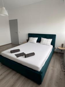 a large bed with white sheets and pillows on it at Mall Torontal Lux Apartament in Timişoara