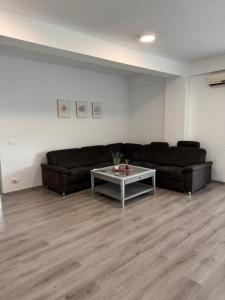 a living room with a couch and a table at Mall Torontal Lux Apartament in Timişoara