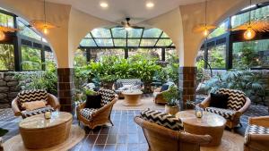 a patio with chairs and tables and windows at Hotel Puerto Palace in Puerto de la Cruz