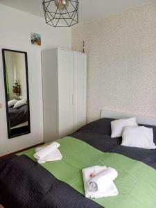 a bedroom with a bed with towels on it at Harmónia Apartman Balatonföldvár in Balatonföldvár