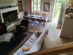 ein Wohnzimmer mit Couch und ein Esszimmer in der Unterkunft Maison charmante à Antezant-la-Chapelle avec jardin in Le Pin-Saint-Denis