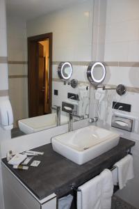 bagno con lavandino e 2 specchi di Grand Hotel Empire a Francoforte sul Meno